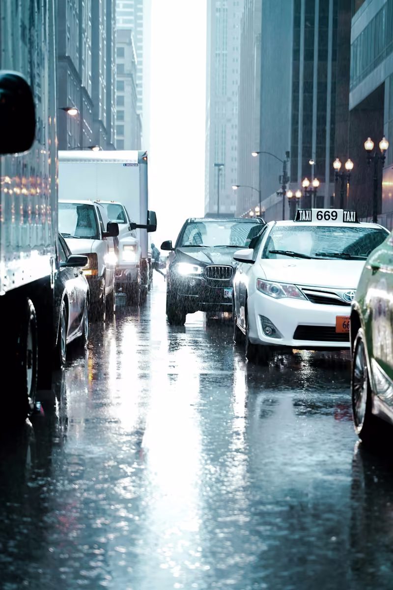 Carros parados no trânsito numa rua molhada de chuva