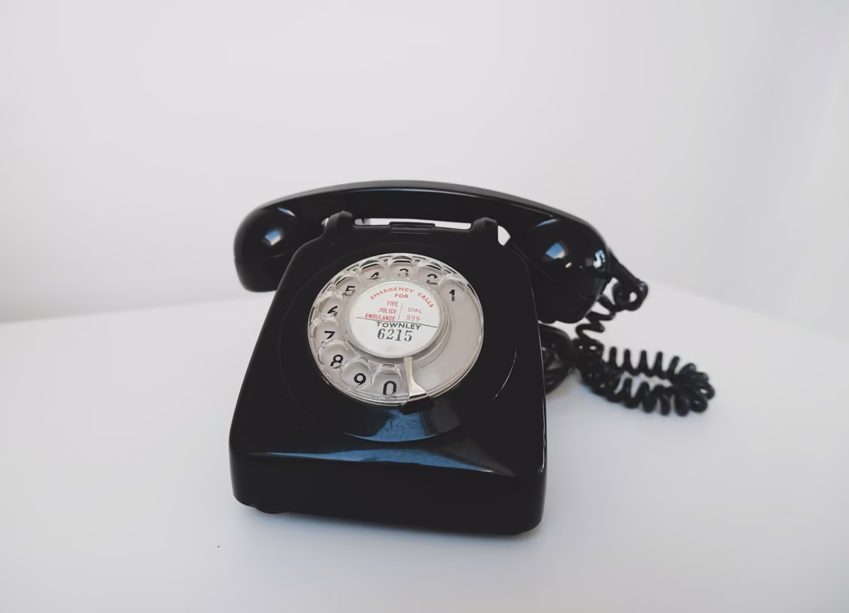 Telefone preto de disco sobre uma superfície branca