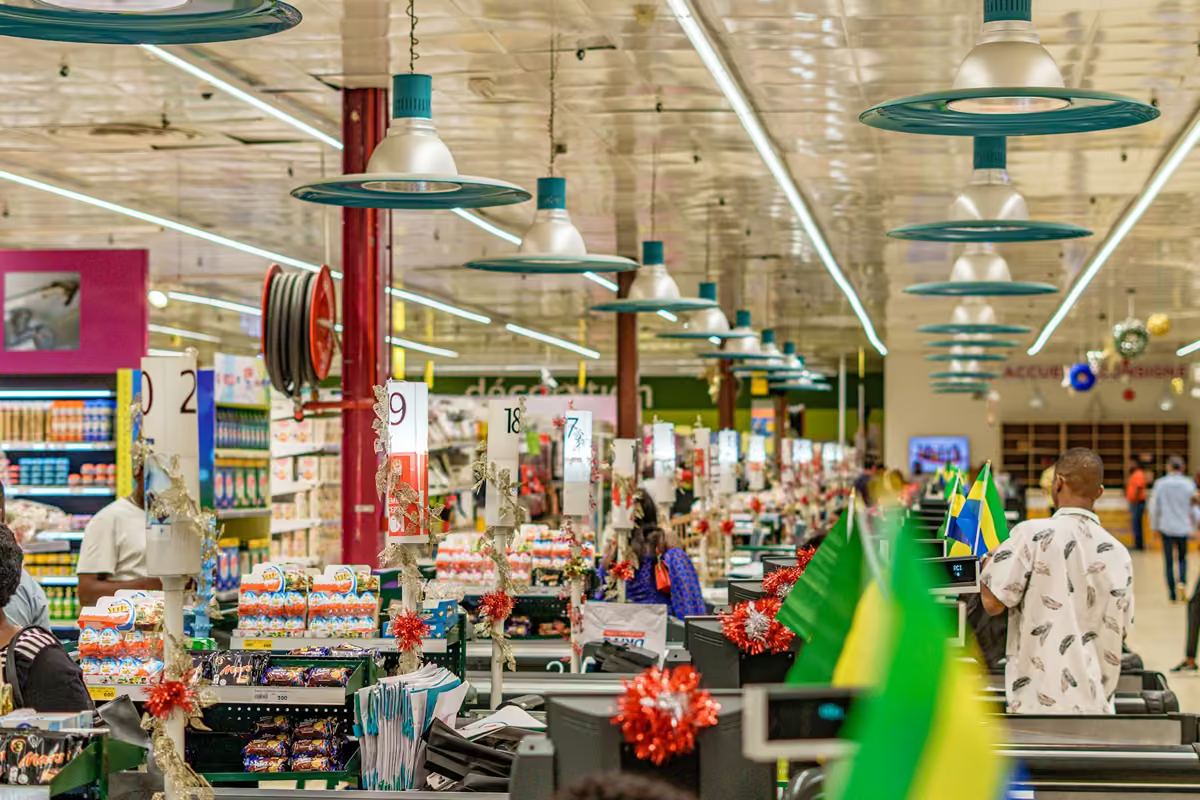 Corredor de supermercado com iluminação forte e muitas pessoas